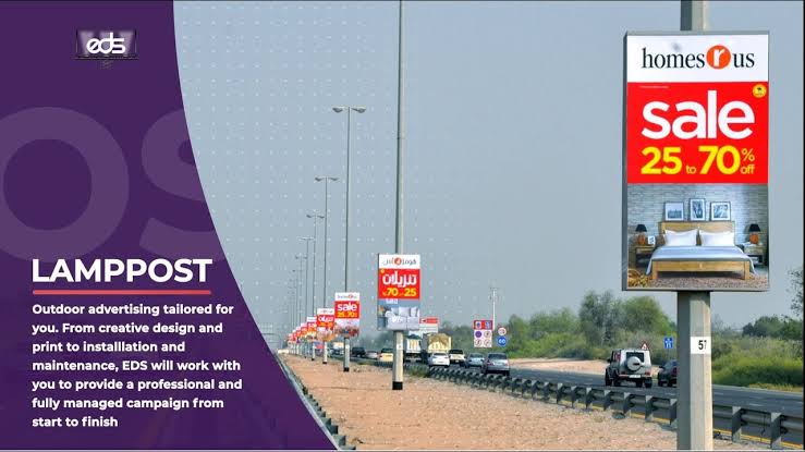 people holding umbrellas on a busy street at night lit by street lights and illuminated signs in Tokyo, Japan